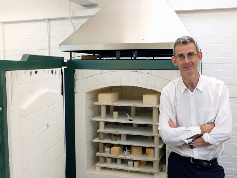 Portrait of Edmund de Waal standing by the kiln in his studio
